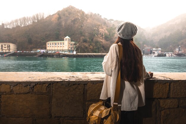 Giovane donna caucasica che visita una vecchia città sul lato del fiume