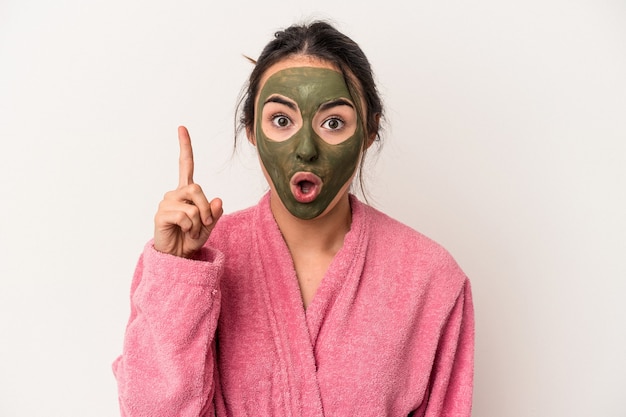 Young caucasian woman wearing a facial mask isolated on white background having some great idea, concept of creativity.