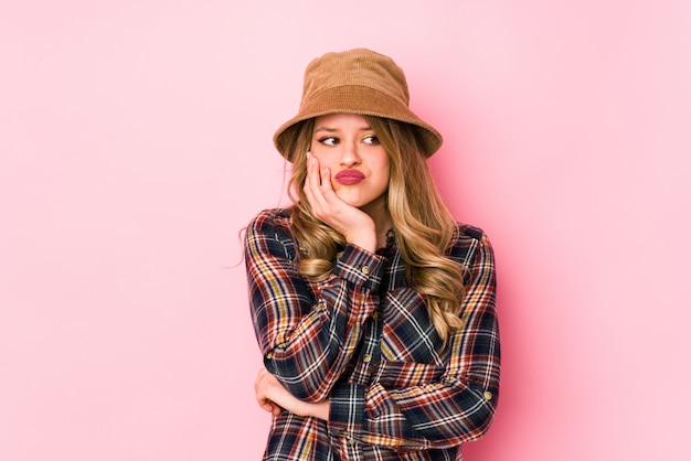 Young caucasian woman wearing a hat isolated who is bored, fatigued and need a relax day.