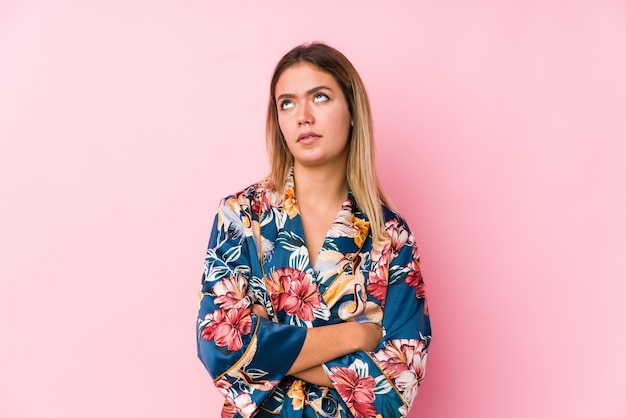 Young caucasian woman wearing pajamas tired of a repetitive task.