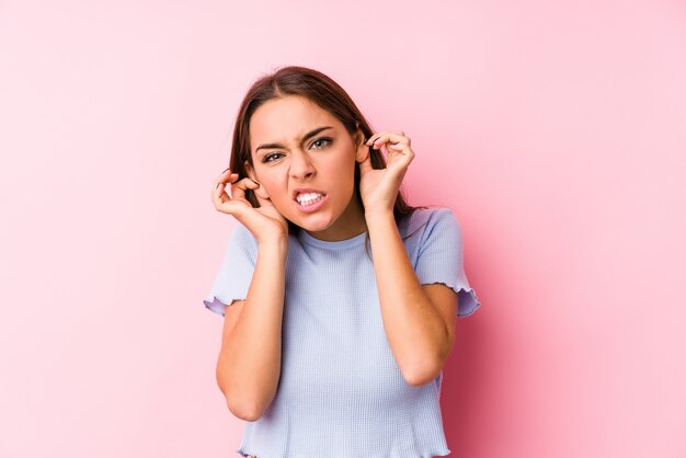 Young caucasian woman wearing a ski clothes isolated covering ears with hands.