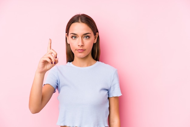 Young caucasian woman wearing a ski clothes isolated showing number one with finger.