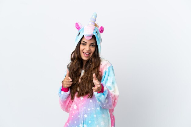 Young caucasian woman wearing a unicorn pajama isolated on white background pointing to the front and smiling