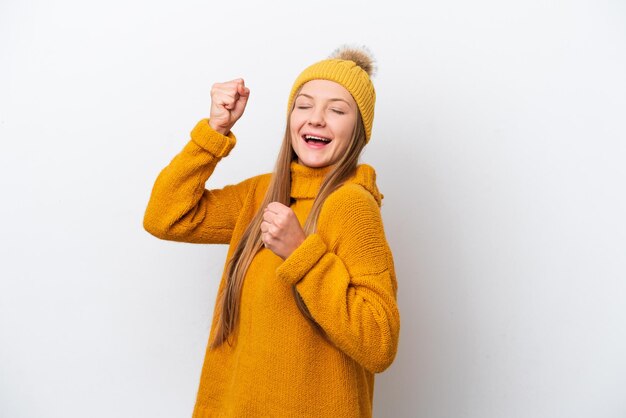 Young caucasian woman wearing winter jacket isolated on white background celebrating a victory