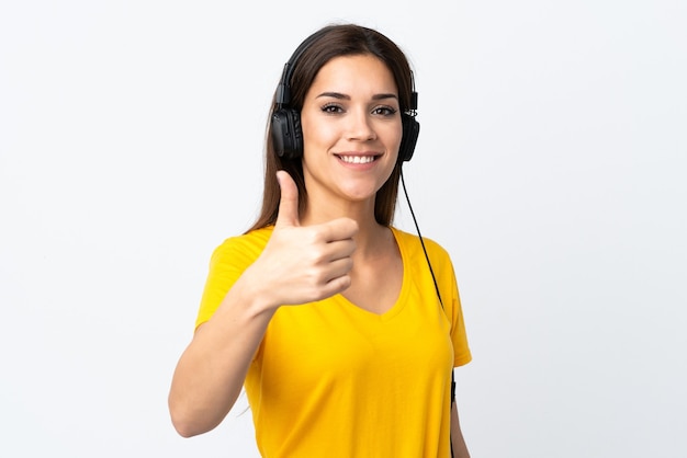 Young caucasian woman on white listening music and with thumb up