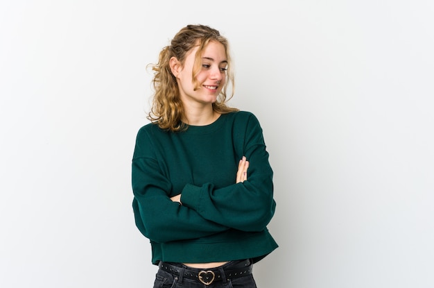 Young caucasian woman on white wall smiling confident with crossed arms.