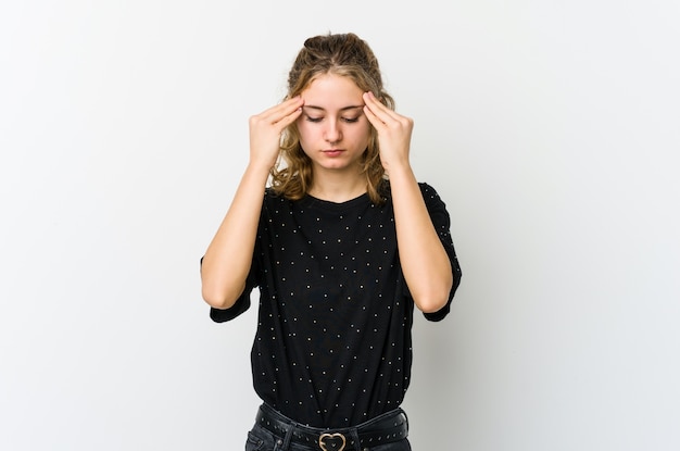 Young caucasian woman on white wall touching temples and having headache.