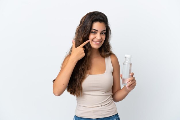 Young caucasian woman with a bottle of water isolated on white background giving a thumbs up gesture