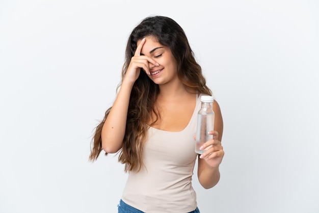 Foto giovane donna caucasica con una bottiglia d'acqua isolata su sfondo bianco ridendo