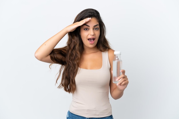 Young caucasian woman with a bottle of water isolated on white background with surprise expression