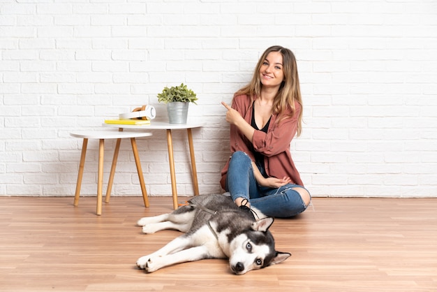 孤立した壁の上の犬を持つ若い白人女性