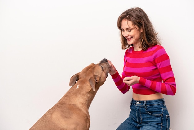 Young caucasian woman with her dog isolated on white background