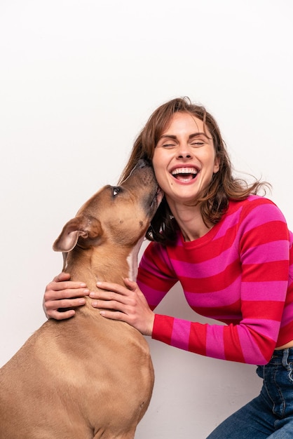 Young caucasian woman with her dog isolated on white background