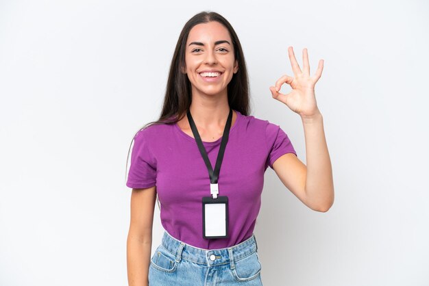 Young caucasian woman with ID card isolated on white background showing ok sign with fingers