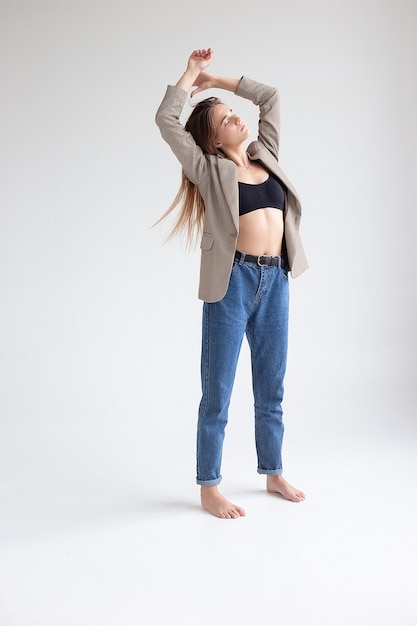 Young caucasian woman with long brown hair in suit jacket on white background