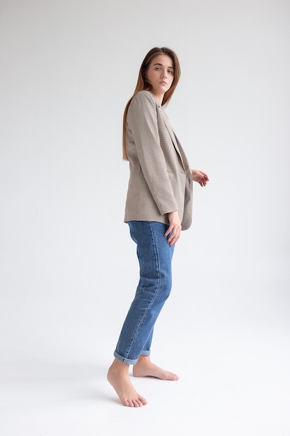 Photo young caucasian woman with long brown hair in suit jacket on white background