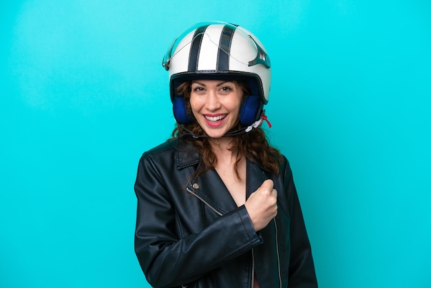 Young caucasian woman with a motorcycle helmet isolated on blue background celebrating a victory