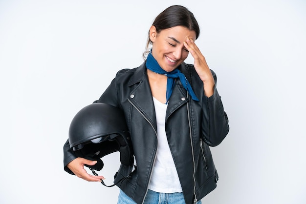 Young caucasian woman with a motorcycle helmet isolated on blue background laughing