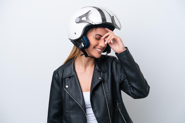 Young caucasian woman with a motorcycle helmet isolated on\
white background laughing