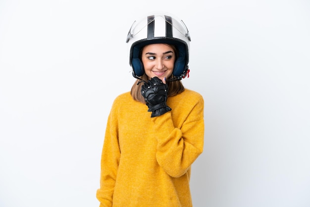 Young caucasian woman with a motorcycle helmet isolated on white background looking to the side and smiling