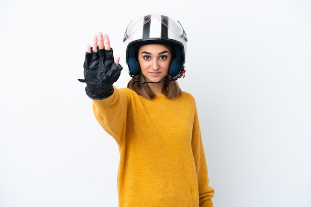 Young caucasian woman with a motorcycle helmet isolated on white background making stop gesture