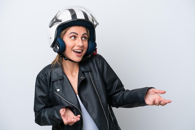 Young caucasian woman with a motorcycle helmet isolated on white background with surprise expression while looking side
