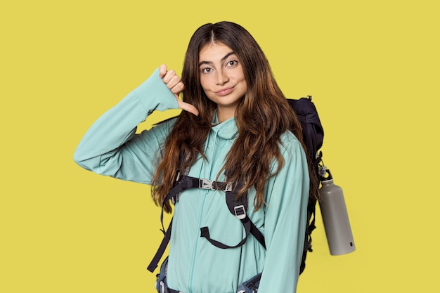 Foto giovane donna caucasica con zaino di montagna che mostra un gesto di antipatia pollici verso il basso