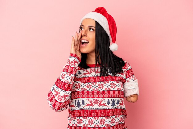 Young caucasian woman with one arm celebrating Christmas isolated on pink background shouting and holding palm near opened mouth.