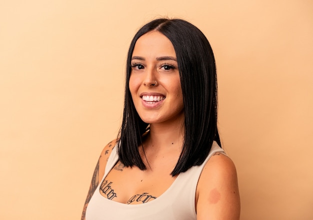 Young caucasian woman with one arm isolated on beige background