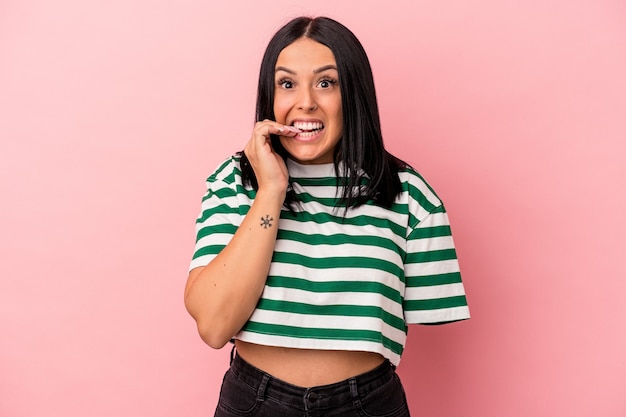 Young caucasian woman with one arm isolated on pink background biting fingernails, nervous and very anxious.