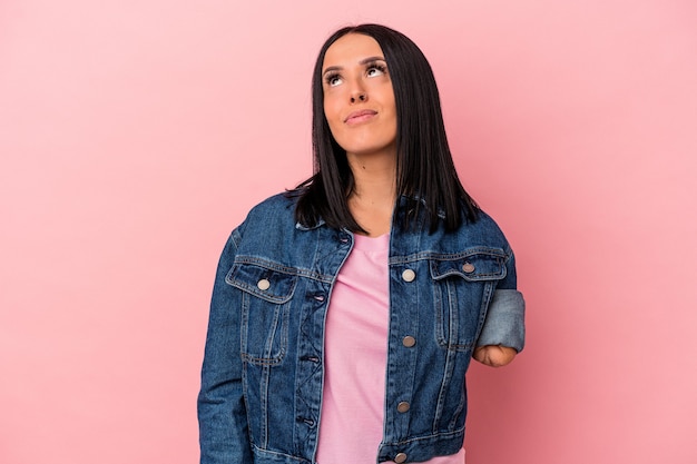 Young caucasian woman with one arm isolated on pink background dreaming of achieving goals and purposes