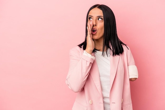 Young caucasian woman with one arm isolated on pink background is saying a secret hot braking news and looking aside