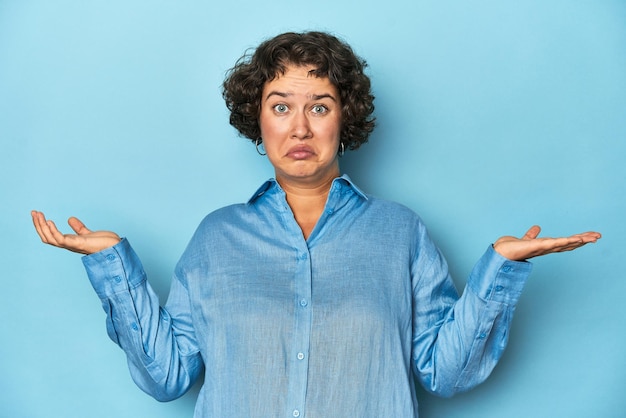 写真 ショートヘアの若い白人女性が疑い,疑問のジェスチャーで肩を挙げている