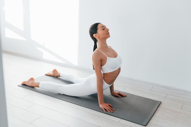 Young caucasian woman with slim body shape is indoors at daytime