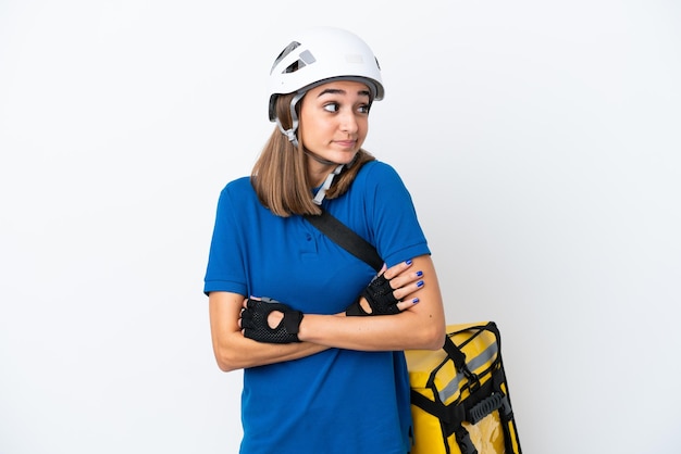 Young caucasian woman with thermal backpack isolated on white background making doubts gesture while lifting the shoulders