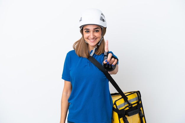 Young caucasian woman with thermal backpack isolated on white background showing and lifting a finger