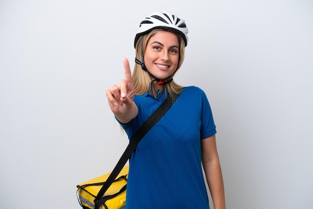 Young caucasian woman with thermal backpack isolated on white background showing and lifting a finger