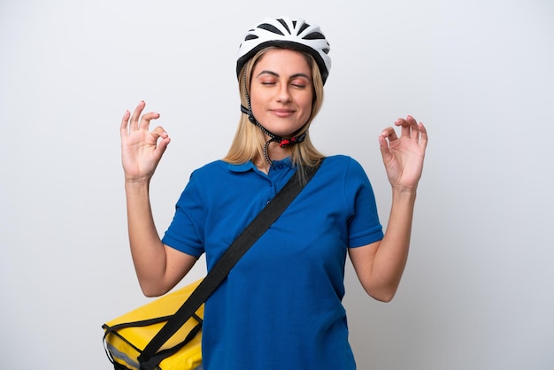 Young caucasian woman with thermal backpack isolated on white background in zen pose