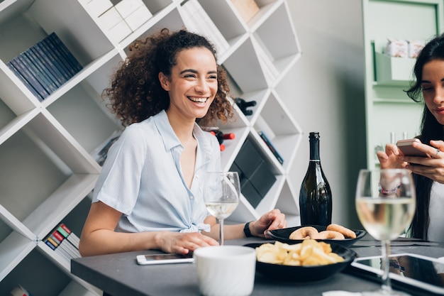 Young caucasian women drinking wine and relaxing in modern restaurant 