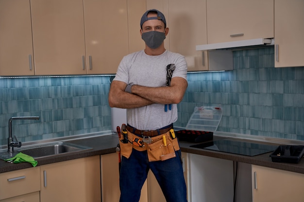 Young caucasian worker standing with crossed hands in kitchen