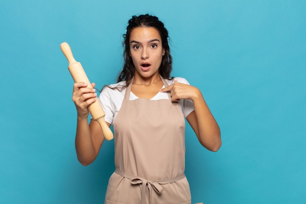 Young caucasic woman looking shocked and surprised with mouth wide open, pointing to self