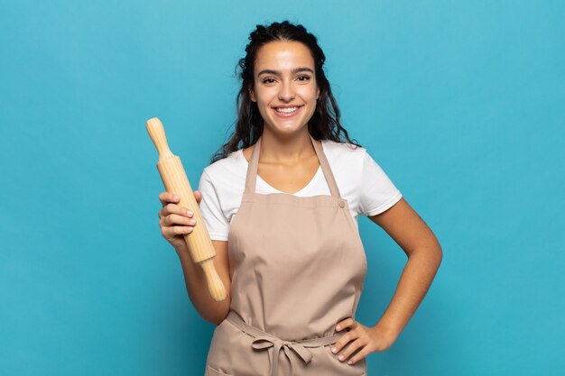 Young caucasic woman smiling happily with a hand on hip and confident, positive, proud and friendly attitude