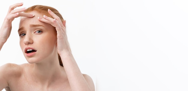 Young caucsian woman squeezes acne on the face of beauty