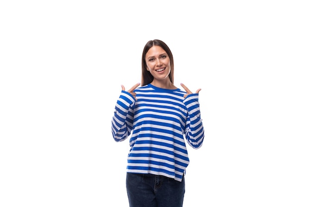 Photo young charming brunette lady in a striped sweater on a white background with copy space people