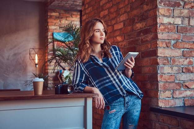 Young charming girl photographer working with a tablet in a stud