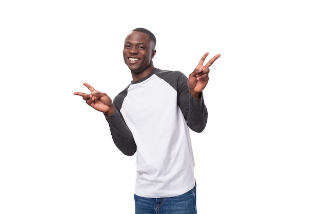 Young charming happy african guy with short haircut dressed in long sleeve summer sweater