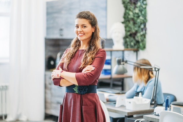 Young charming smiling woman owner of beauty salon nail bar, concept of own small business