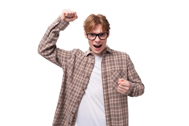 Photo young charming student guy with red hair in glasses on a white background