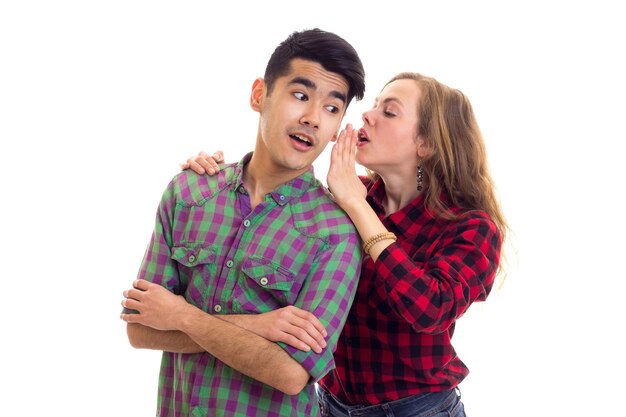 Young charming woman talking to young pleasant man with dark hair in plaid shirt