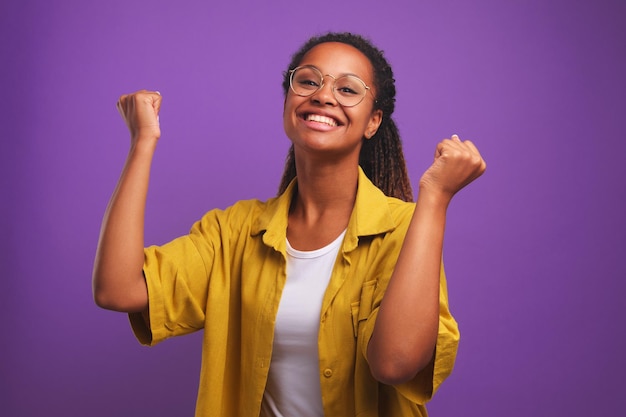 Young cheerful African American woman student smiling broadly and waving hands